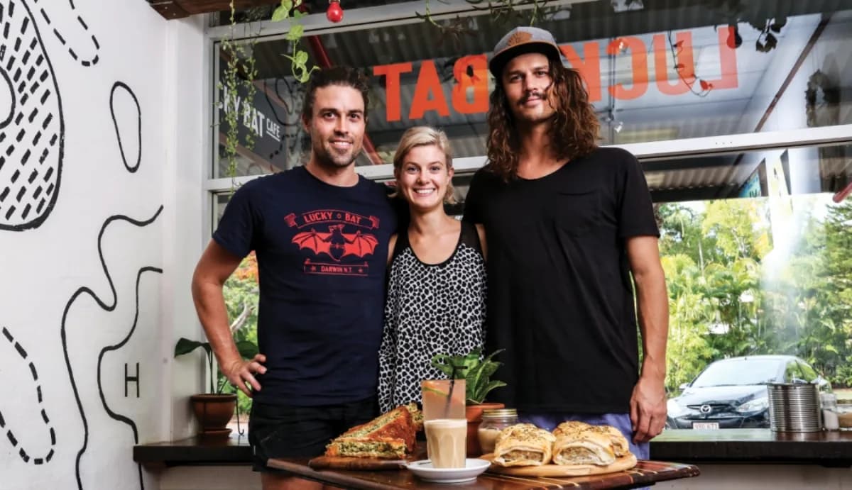 Lucky Bat team behind the counter with food spread and cafe signage