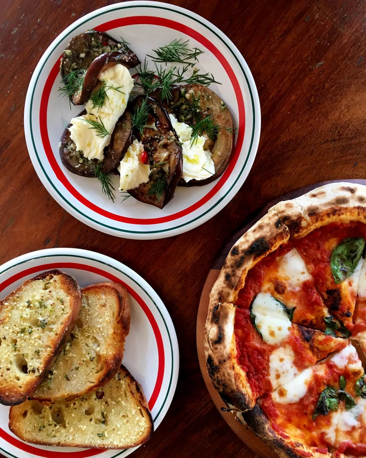 Food spread with bruschetta, garlic bread, and margherita pizza