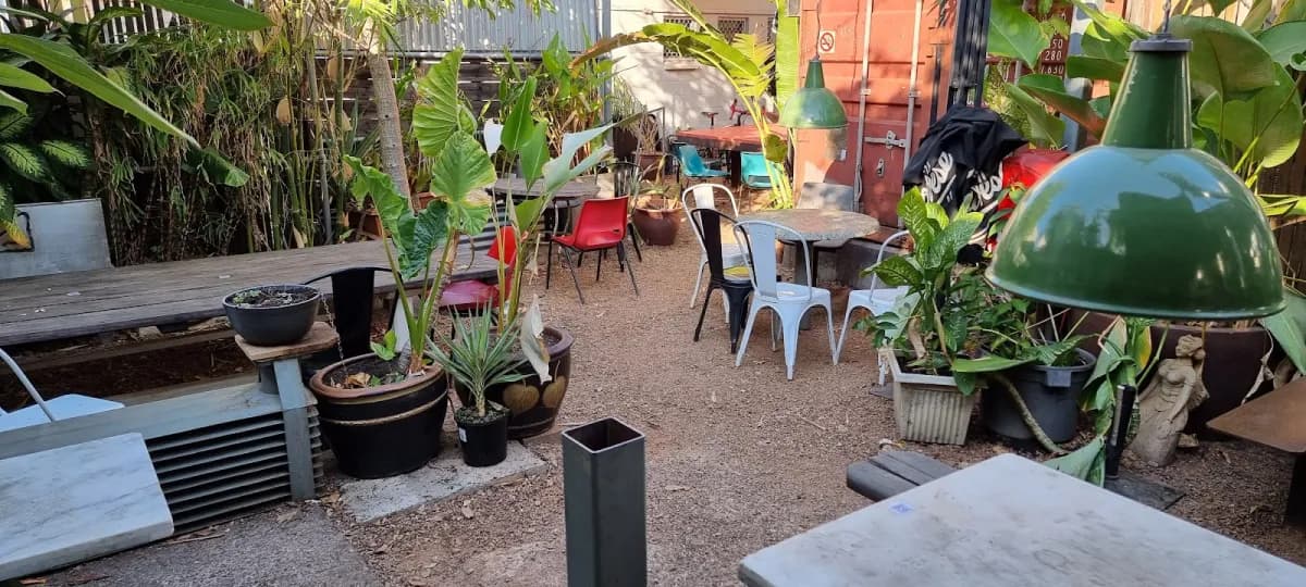 Lush tropical outdoor courtyard with vintage chairs and banana palms